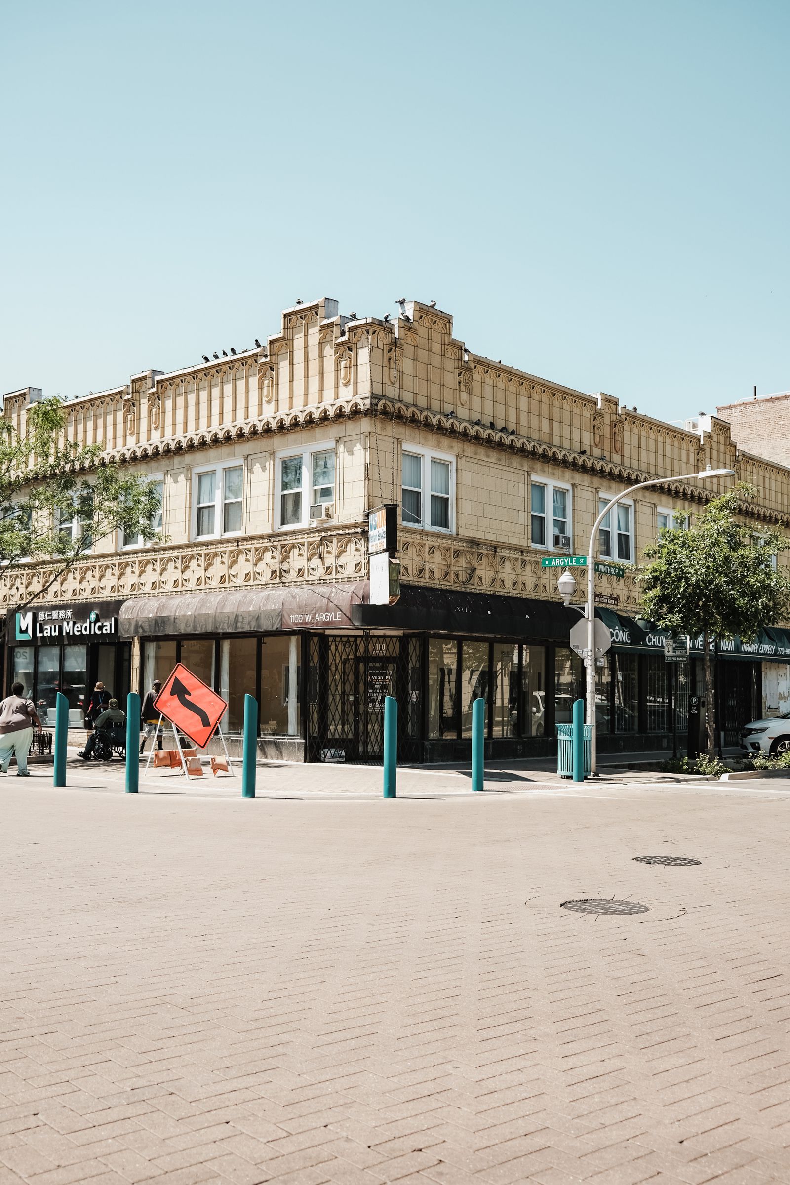 A sunlit neighborhood street corner with storefronts in Chicago