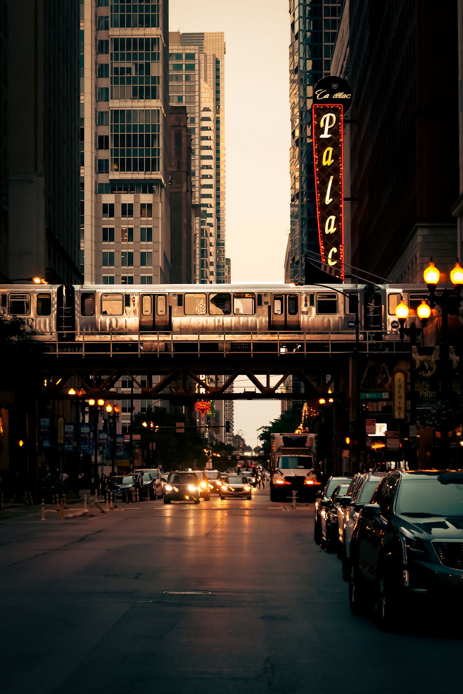 A Chicago elevated train crossing above a downtown street at twilight